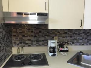 a kitchen counter with a coffee maker and a sink at East Street Inn & Suites in Tipton +9 photos