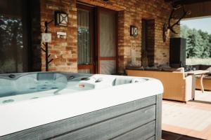 a bath tub in a bathroom with a patio at Smaragd Vendégház in Sitke