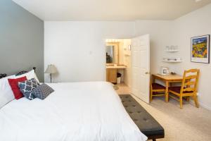 een slaapkamer met een wit bed en een bureau bij Cimarron Lodge 50 by AvantStay Ski-InSki-Out Property in Complex w Two Hot Tubs in Telluride