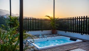 a hot tub on a patio with a fence at Chakk 109 Mussoorie Foothills, Dehradun in Dehradun