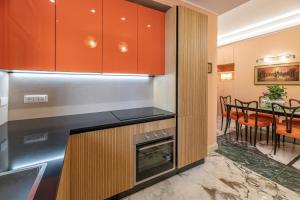 una cucina con armadi arancioni e tavolo con sedie di Tu chiamale emozioni 3 suite a Roma Altre 37 foto
