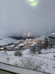 a city covered in snow with buildings and houses at Maribel Arttyco a pie de pista con Parking cubierto in Sierra Nevada