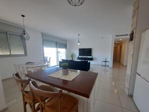 a kitchen and living room with a table and chairs at דירת אירוח בפרדס חנה in Pardes H̱anna