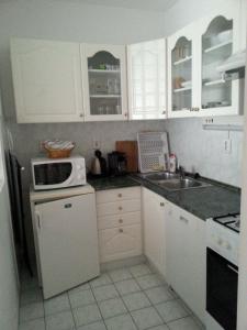 ヘーヴィーズにあるPedestrian Street Apartmentの小さなキッチン(白いキャビネット、シンク付)