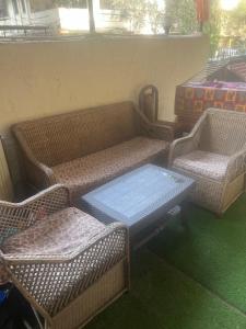 two wicker chairs and a couch and a table at 3BHK in Nerul,near DY Patil Stadium & Wonders Park in Navi Mumbai