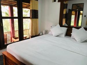 uma grande cama branca num quarto com janelas em Turn View Resort Ella em Ella