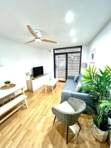 a living room with a blue couch and a ceiling fan at Apartamento La Sal in León