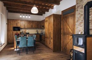 a kitchen with wooden cabinets and a table and chairs at Zafír Vendégház in Sitke