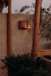 a light on the side of a wall with trees at Maison Dar Saada in Marrakesh +91 photos