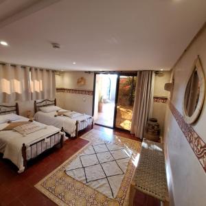 una camera con 2 letti e una porta che conduce a un patio di L'abri côtier by Nath a Sidi Kaouki