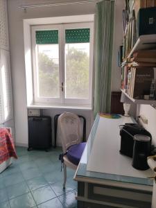 Cette chambre dispose d'une fenêtre, d'une table et d'une chaise. dans l'établissement U' Pizzico ( the pinch ), à Capri