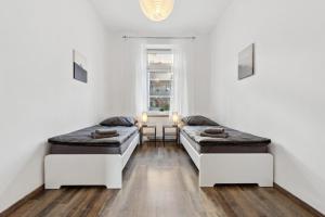 two beds in a room with a table and a window at KA01 Schicke Wohnung in Worms! in Worms