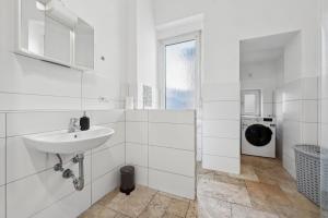a white bathroom with a sink and a washing machine at KA01 Schicke Wohnung in Worms! in Worms