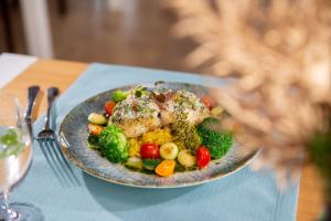 a plate of food with vegetables on a table at Hotel Aqua Sopot - Destigo Hotels in Sopot