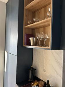 une cuisine avec des armoires en bois avec des bols et des ustensiles dans l'établissement COP 30 Luxury Apartment, à Belém