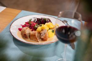 a plate of food on a table with a glass of wine at Hotel Aqua Sopot - Destigo Hotels in Sopot