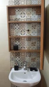 a white sink in a bathroom with tiles on the wall at Luxurious space in Oulad Kerroum