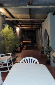 a table and chairs in a room with a table and chairs at Tesselaarsdal Backpackers & Koshuis in Caledon