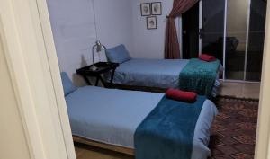 a room with two beds and a couch in it at Tesselaarsdal Backpackers & Koshuis in Caledon +3 photos