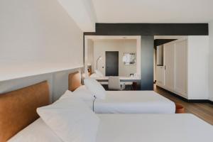 a hotel room with two beds and a desk at Hotel Dimar in Valencia