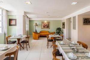 a dining room with tables and chairs and a couch at Hotel Erechim in Porto Alegre +46 photos