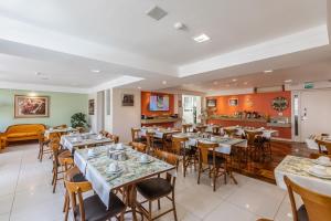 a restaurant with tables and chairs in a room at Hotel Erechim in Porto Alegre