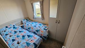 CrowleにあるWillows Cosy Hideaway on 7 Lakesのベッドと窓のある小さな寝室