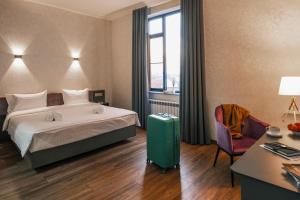 a hotel room with a bed and a chair at Parklane Hotel in Tashkent