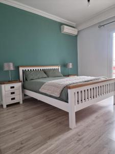 a bedroom with a bed and a blue wall at Kouros Villa and Apartment in Ágios Nikólaos