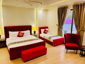 斯瓦特The Corporate Lodges Hotel by Khan Familia Travels的卧室里有一张红床和一把椅子 更多33张照片