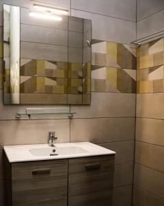 a bathroom with a sink and a mirror at Stylish 2BR Modern Apt in Cité Baguida in Lomé +26 photos