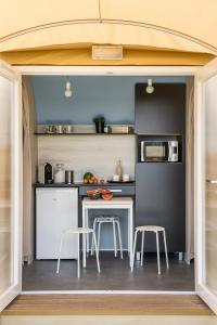 an open kitchen with a table and stools at AIRE NATURELLE CAMPING LA LOIRE FLEURIE in Le Perrier