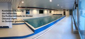 a swimming pool in a building with a sign on the wall at Ferienwohnung Jones in Pany