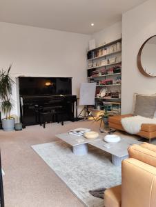 a living room with a couch and a piano at Cosy oasis with a view in London
