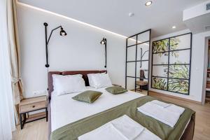 a bedroom with a large white bed with two pillows at Olive Villas Beach Hotel in Sozopol