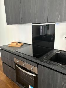 a kitchen with a black counter top with a microwave at settala 10 apartments in Milan +33 photos