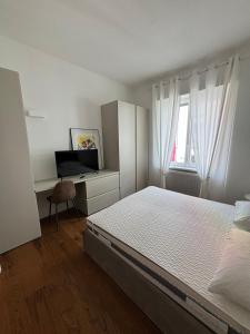 a bedroom with a bed and a desk with a television at settala 10 apartments in Milan