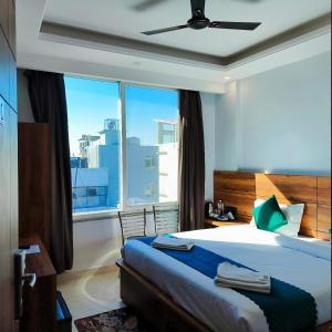 a bedroom with a bed and a large window at Hotel Vaidik Ganga in Rishīkesh
