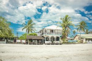 a white house with palm trees on the beach at Chez Senga in Madirokely
