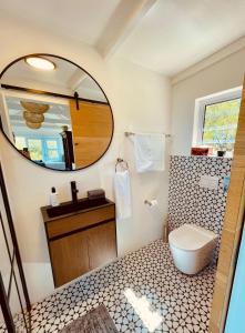 un baño con inodoro y espejo en Sea Views, Hikes & Tranquility Clifftop Cabin, en Plettenberg Bay
