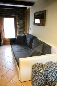 a living room with a grey couch in a room at Apartament Cal Barracaire in Vilallonga de Ter +15 photos