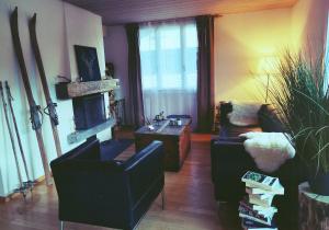 a living room with two chairs and a fireplace at Chalet Sonnenhof Wengen in Wengen