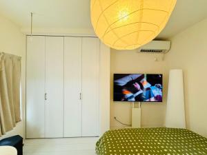 a bedroom with a bed and a tv on the wall at Ikebukuro House-TS0378 in Tokyo