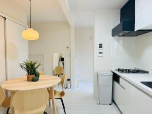 a kitchen and dining room with a wooden table and chairs at Ikebukuro House-TS0378 in Tokyo