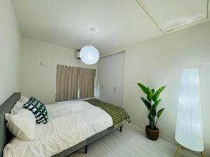 a bedroom with a bed and a potted plant at Ikebukuro House-TS0378 in Tokyo