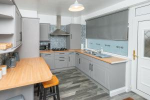 a kitchen with white cabinets and a wooden counter top at Aberdeen Nest in Aberdeen