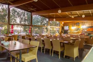 un comedor con mesas, sillas y ventanas en Mannum Motel, en Mannum