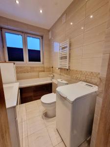 ラドムにあるMieszkanie z dostępem na kodのトイレ、洗面台、浴槽を備えたバスルーム