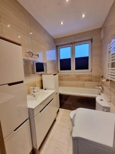 ラドムにあるMieszkanie z dostępem na kodの洗面台、トイレ、浴槽を備えたバスルーム