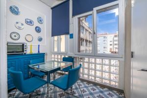 a dining room with a glass table and blue chairs at Portuguese Charm in Lisbon in Lisbon